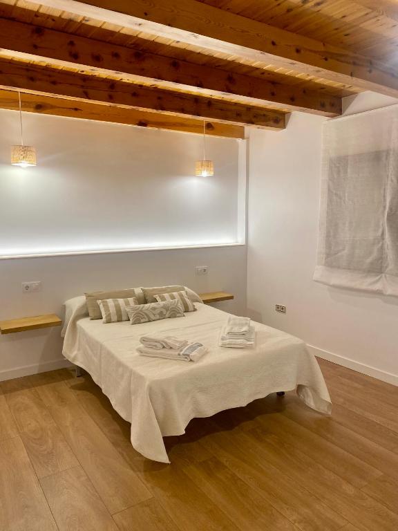 Un dormitorio con una cama en una habitación con techos de madera. en La espiga de Segovia 2, en La Lastrilla