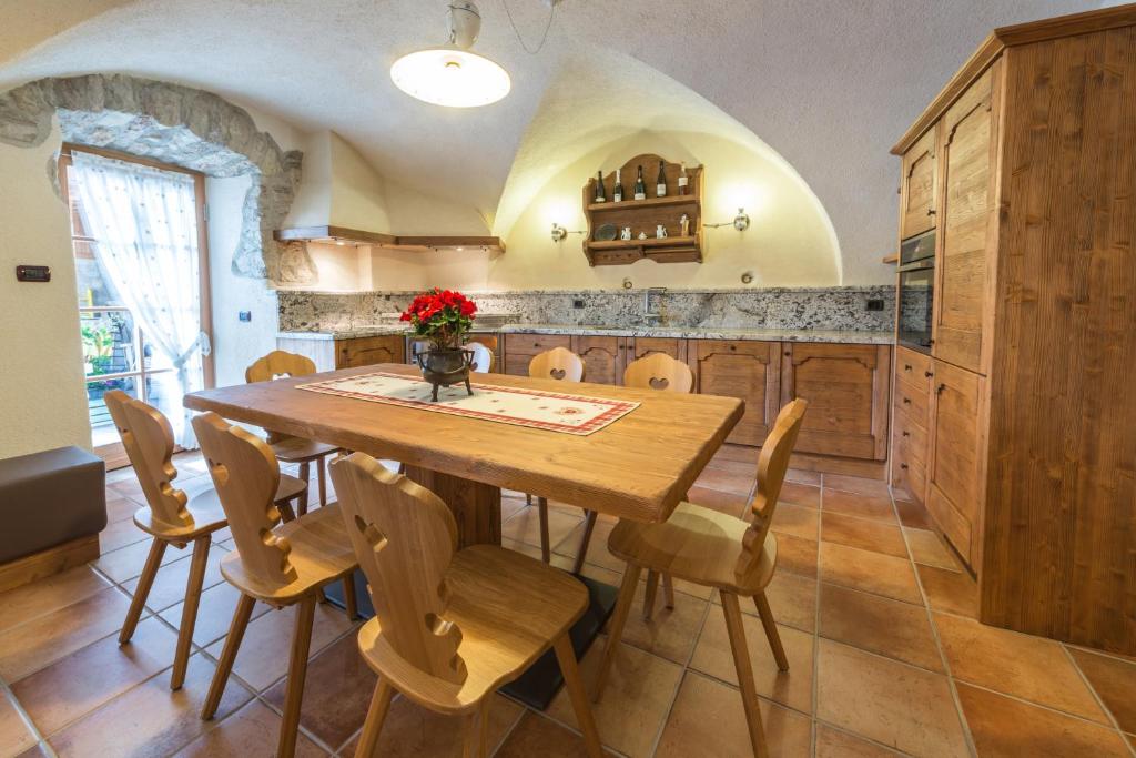 uma cozinha com uma mesa de madeira e cadeiras em Agritur Casa Fabri em Coredo