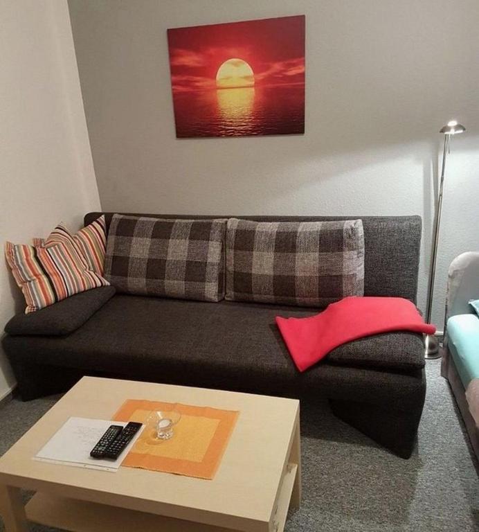 uma sala de estar com um sofá preto e uma mesa de centro em Krappe - ABC75 em Wismar