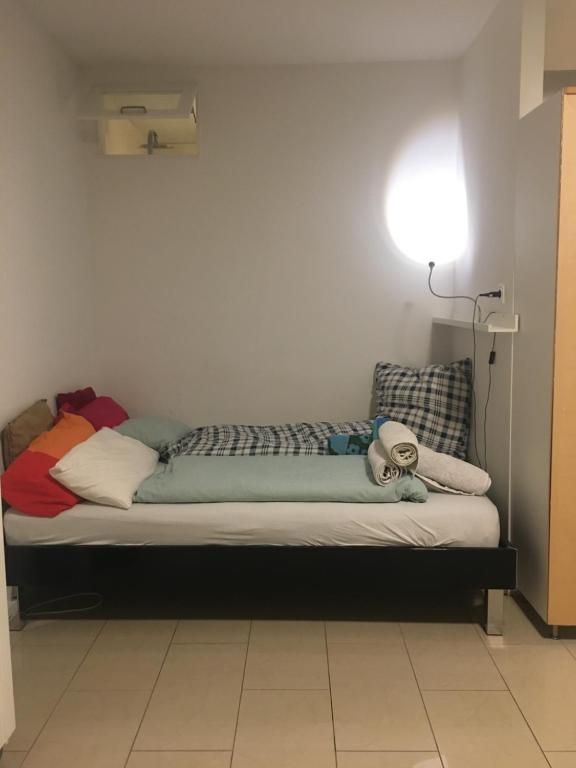 Bett in einem Zimmer mit Wandlicht in der Unterkunft Sky view Neukölln in Berlin