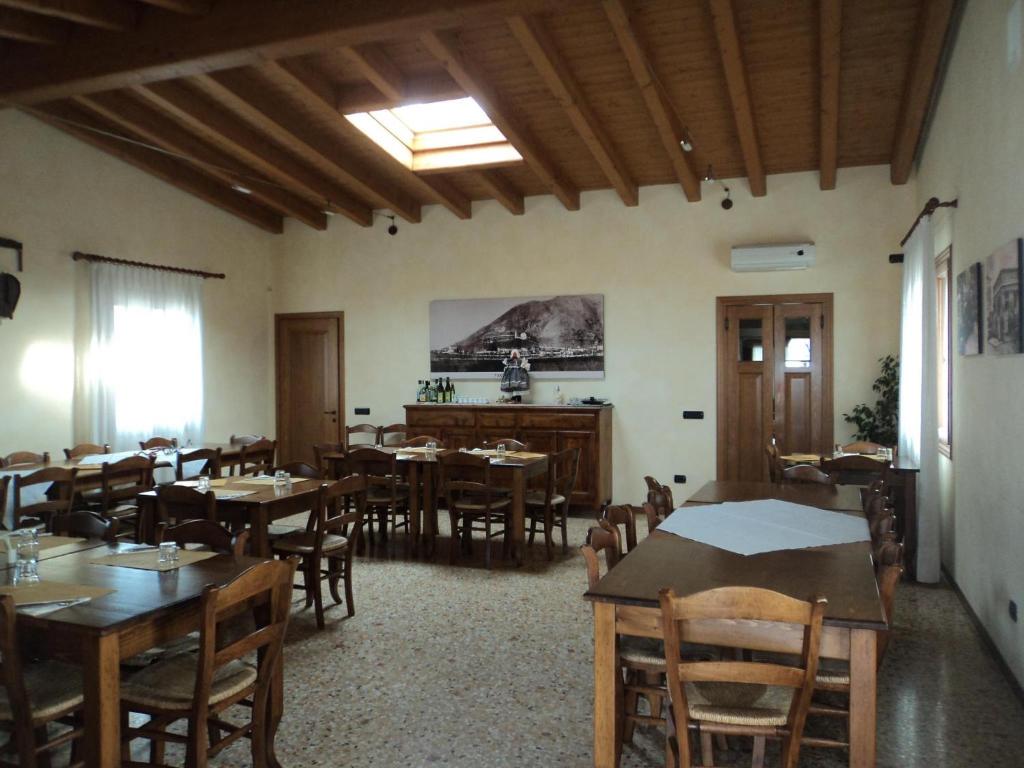 una sala da pranzo con tavoli e sedie in legno di Agriturismo da Mea a Santorso