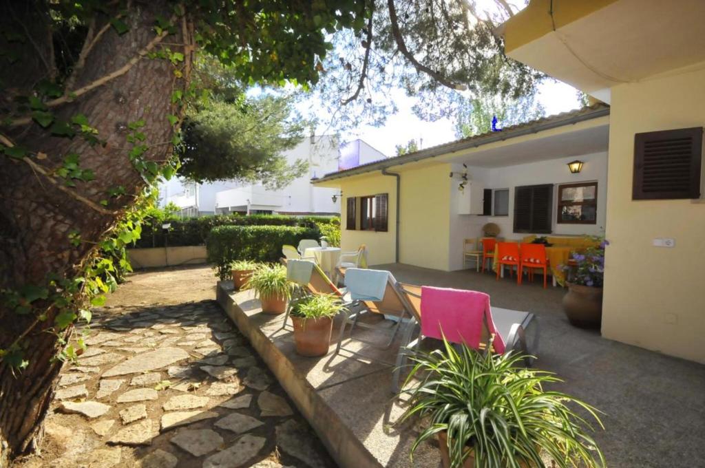 a patio with chairs and plants in a yard at Cora in Port d'Alcudia