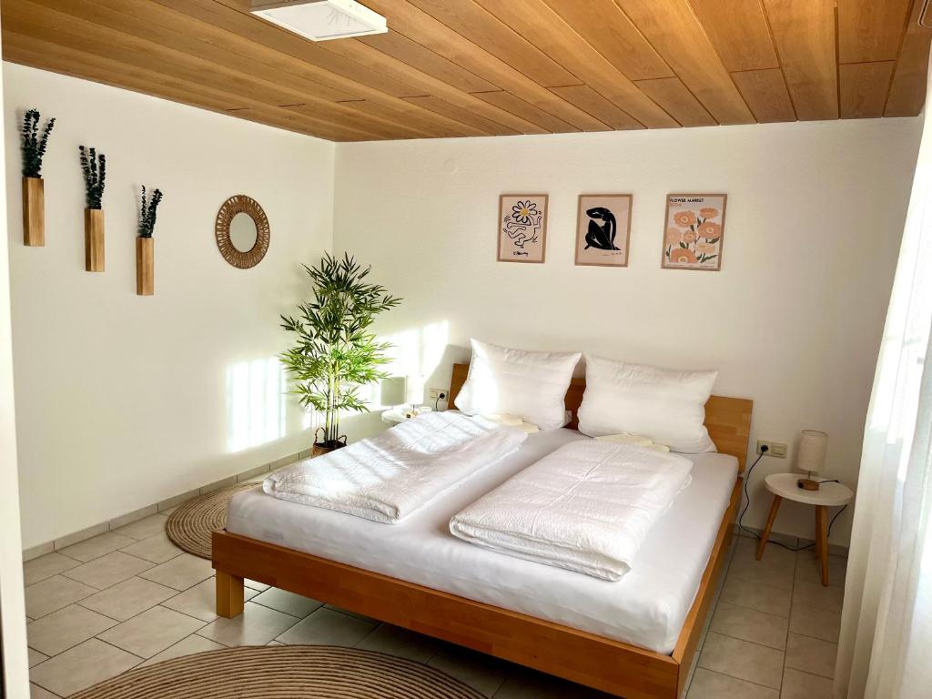 1 dormitorio con 1 cama con techo de madera en Ferienwohnung SeeLiebeee, en Friedrichshafen