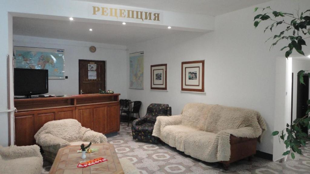 a living room with two chairs and a flat screen tv at Намира се под връх Исполин,на 5км от Шипка,има 300м ски писта със Чайна и ски гардероб+детски шейни,паркинг, Леглова база-35 места разпределени в 11 стаи,всички стаи са със самостоятелна баня и тоалетна. 