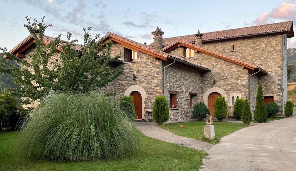 una gran casa de ladrillo con un patio de hierba en Condado de San Martín, en Boltaña