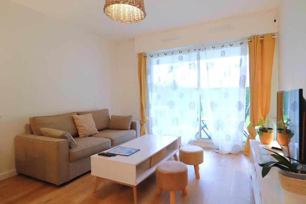 un salon avec un canapé et une table dans l'établissement Olivia - T2 - confort - wifi- parking, à Vannes