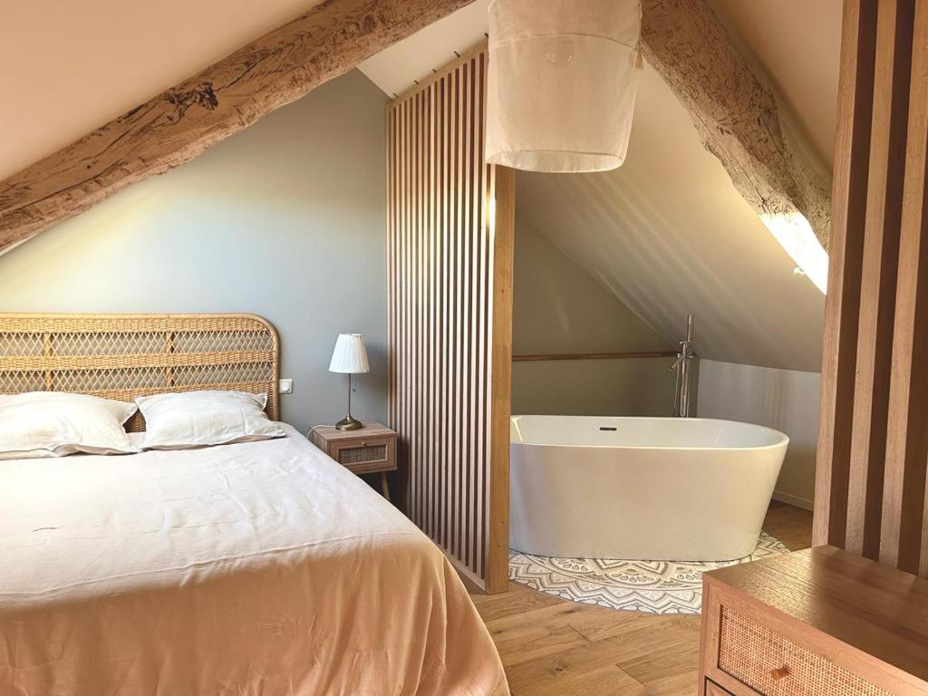 une chambre avec un lit et une baignoire dans l'établissement Charmante maison de campagne, à Saint-Michel-Labadié