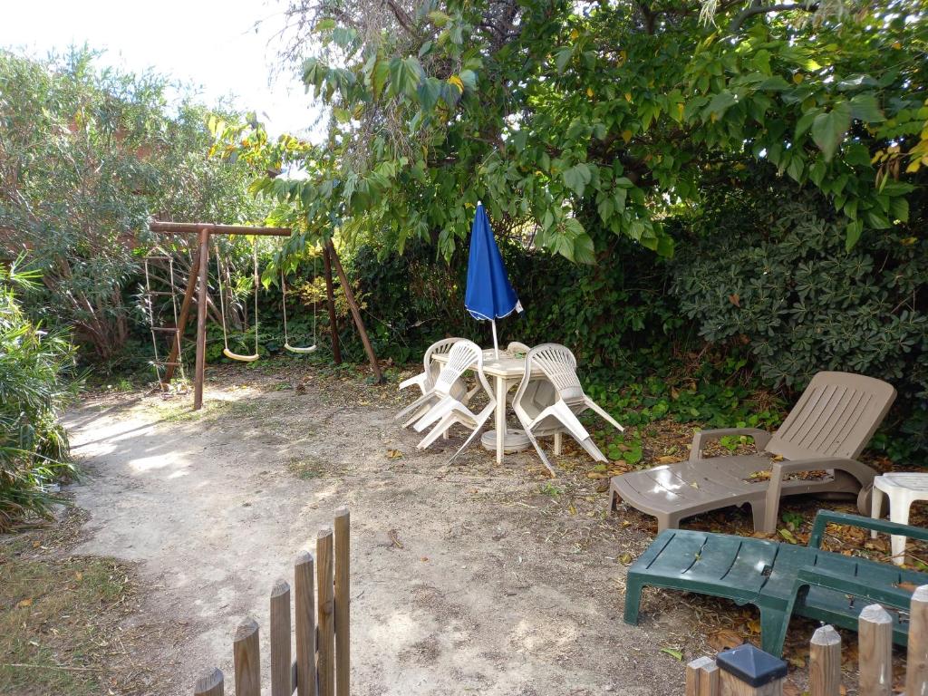 un groupe de chaises, une table et un parapluie bleu dans l'établissement la golondrina, à Frontignan