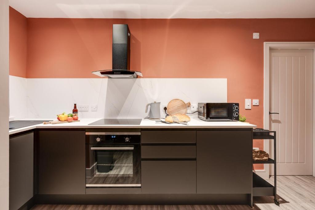 een keuken met een fornuis en een magnetron bij Beach Apartment - 2 Bedrooms Free WiFi Parking in Cleveleys