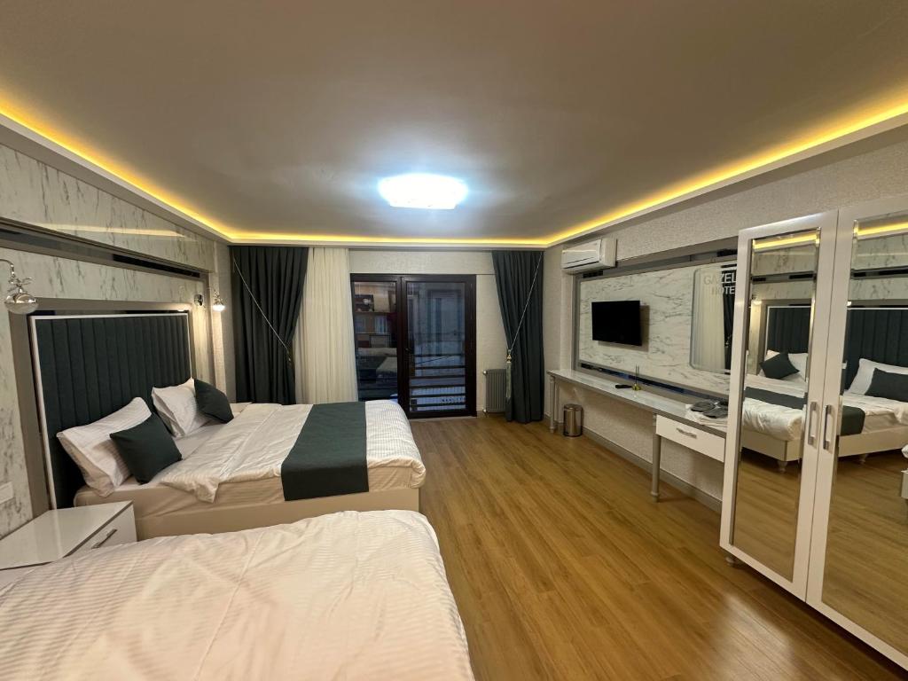 a hotel room with two beds and a television at gazelle suites in Istanbul