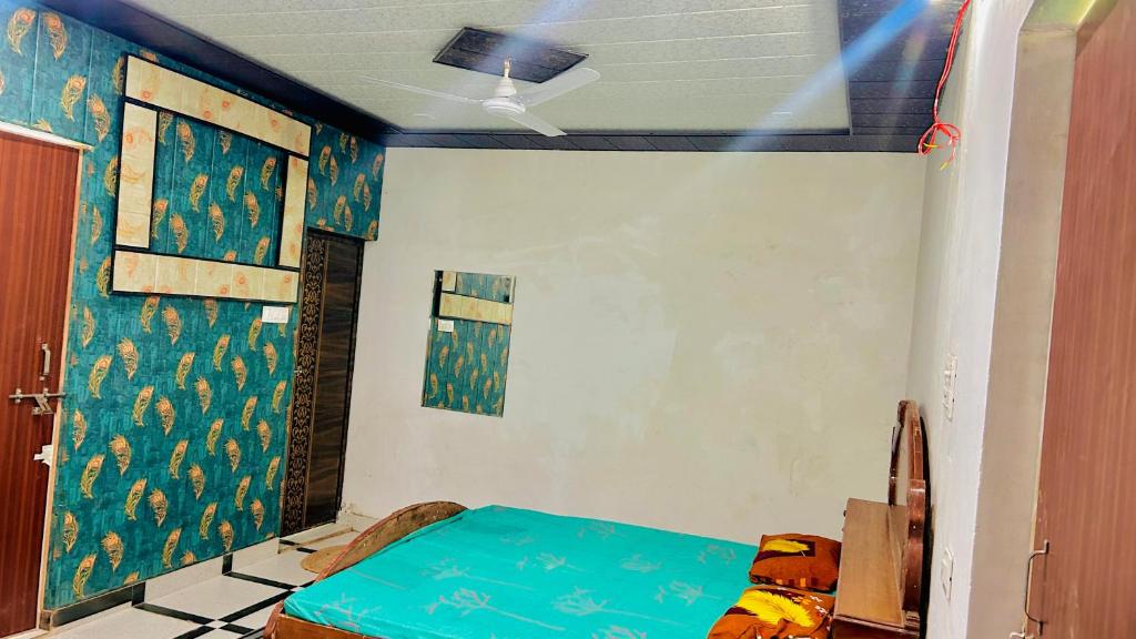 a room with a bed and a wall with a painting at Radhey Krishna home stay in Mathura