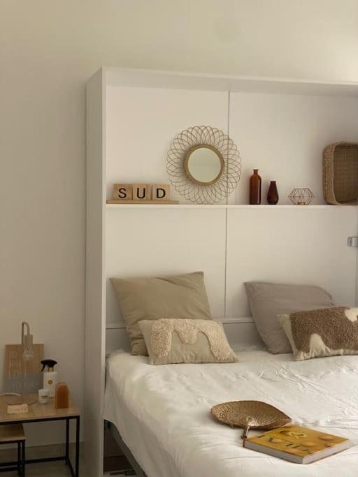 une chambre avec un lit et un miroir au mur dans l'établissement Studio refait à neuf face mer, à Cannes