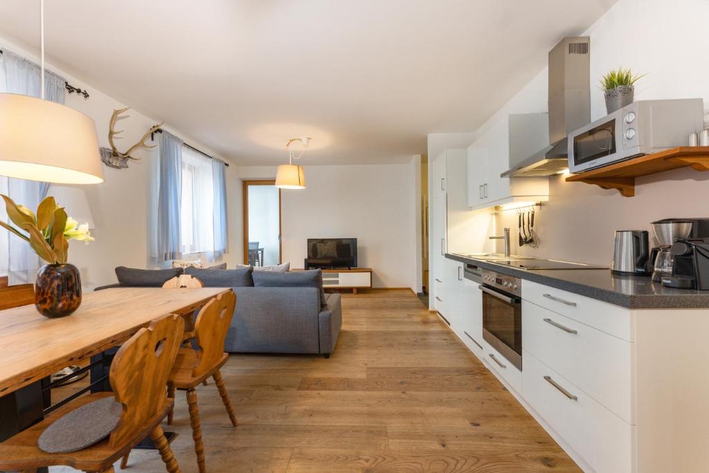 cocina y sala de estar con mesa y sofá en Appartement Hoam by Schladming Appartements, en Schladming