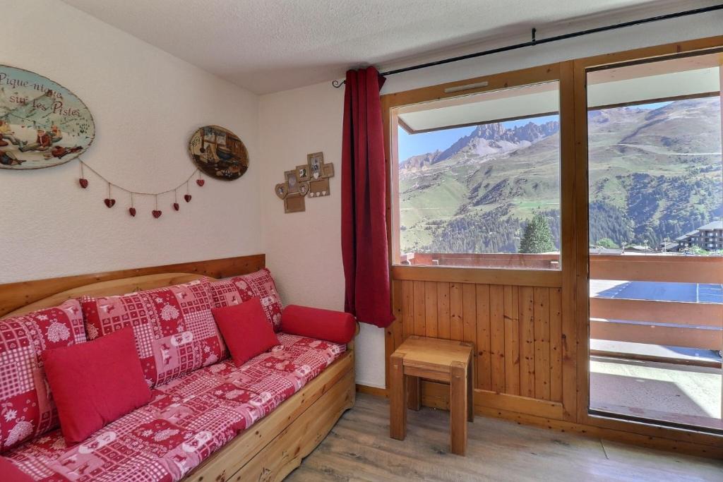 ein Wohnzimmer mit Couch und großem Fenster in der Unterkunft Cimes 2 B17 in Méribel