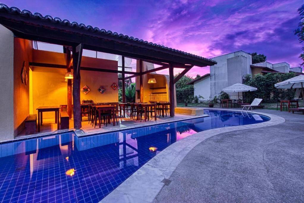 een villa met een zwembad en een huis bij Flat Kite Blue in Pipa
