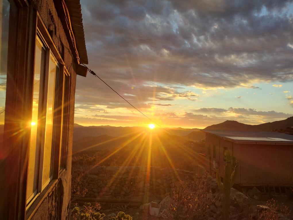 a sunset seen from a window of a house at Cabaña equipada a 300 metros del observatorio mamalluca in Vicuña