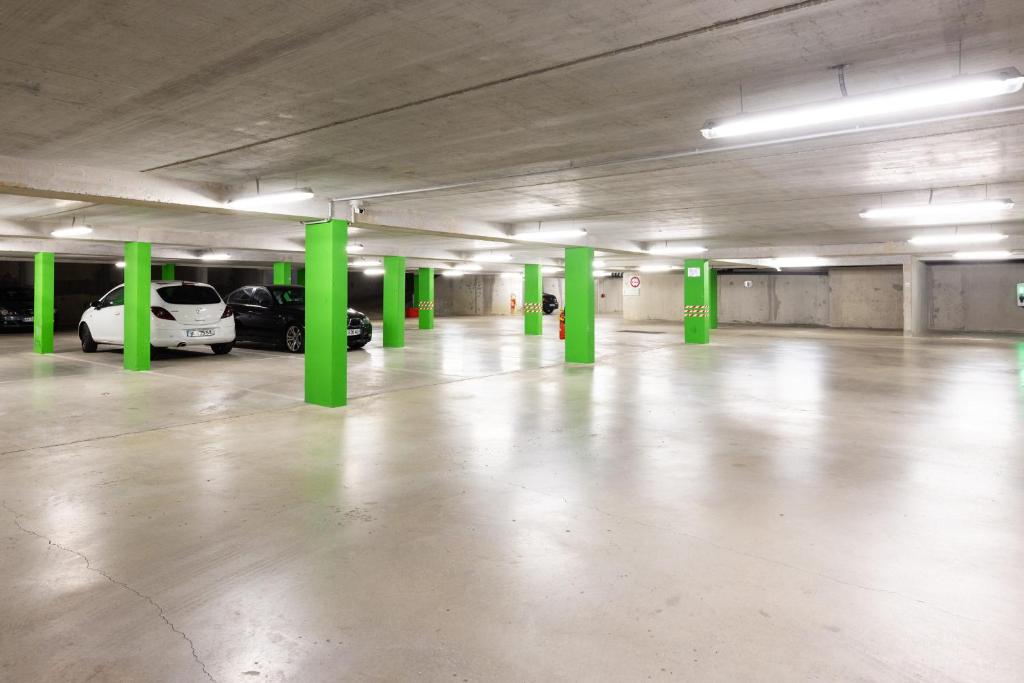 an empty parking garage with green columns and cars at Campanile Limoges Centre - Gare in Limoges