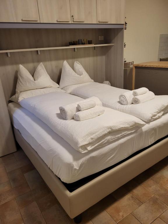 two beds with white sheets and towels on them at Piccolo Loft in Foligno