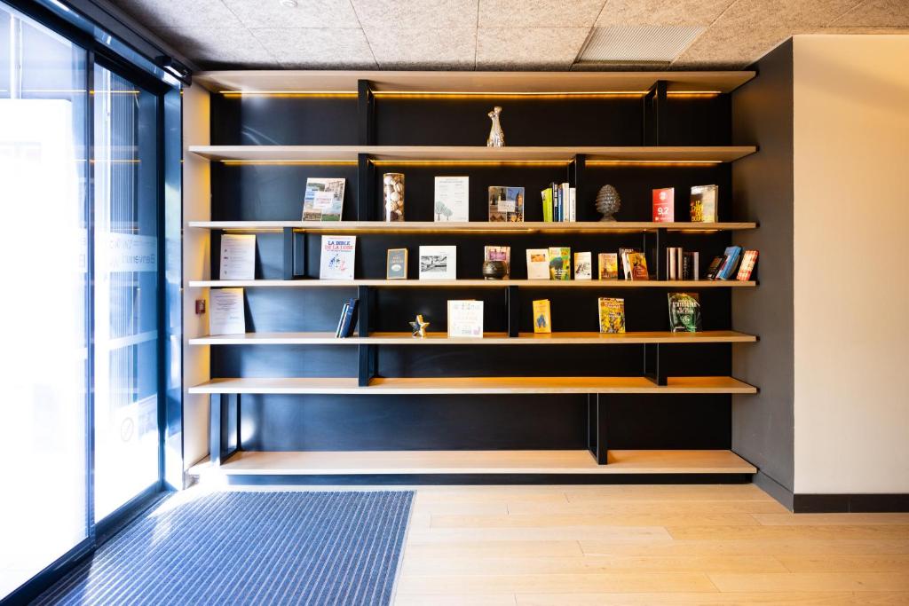 a book shelf in a room with books at Campanile Limoges Centre - Gare in Limoges