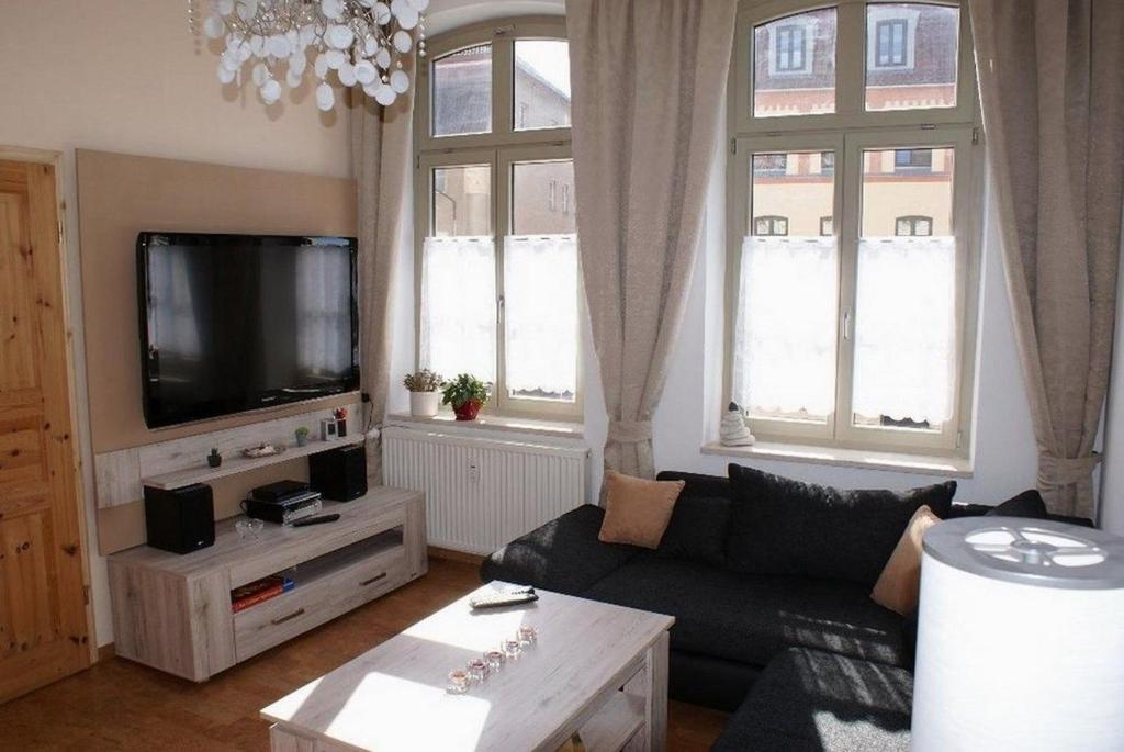 ein Wohnzimmer mit einem Sofa und einem Flachbild-TV in der Unterkunft Seestern am Hafen - ABC139 in Wismar
