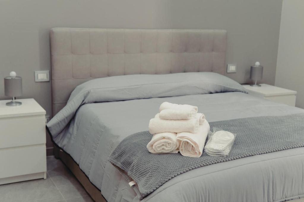 Un dormitorio con una cama con toallas. en Trinacria Home 116, en Catania