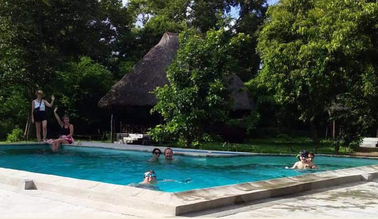 een groep mensen in een zwembad bij The Nyerere Selous Ngalawa Tented Camp in Kwangwazi