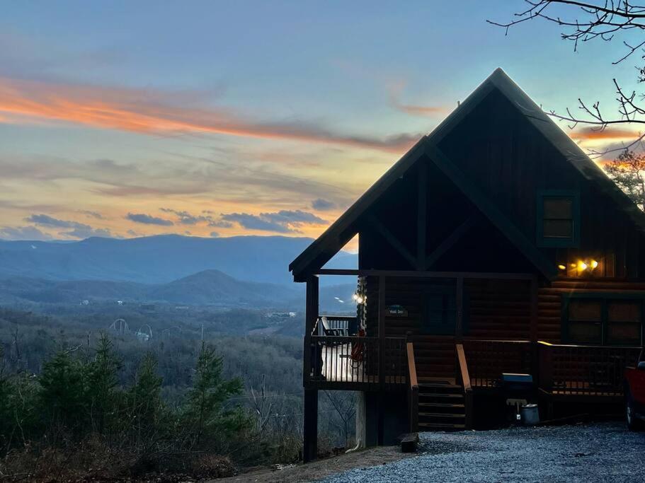 a log cabin with a sunset in the background at Yogi's Den: Breathtaking Views! 3 min to Dollywood, on 1 acre! in Sevierville