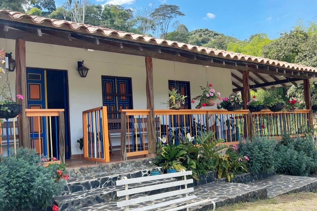 a house with a porch with flowers and plants at Finca Sierra Luz in Jericó