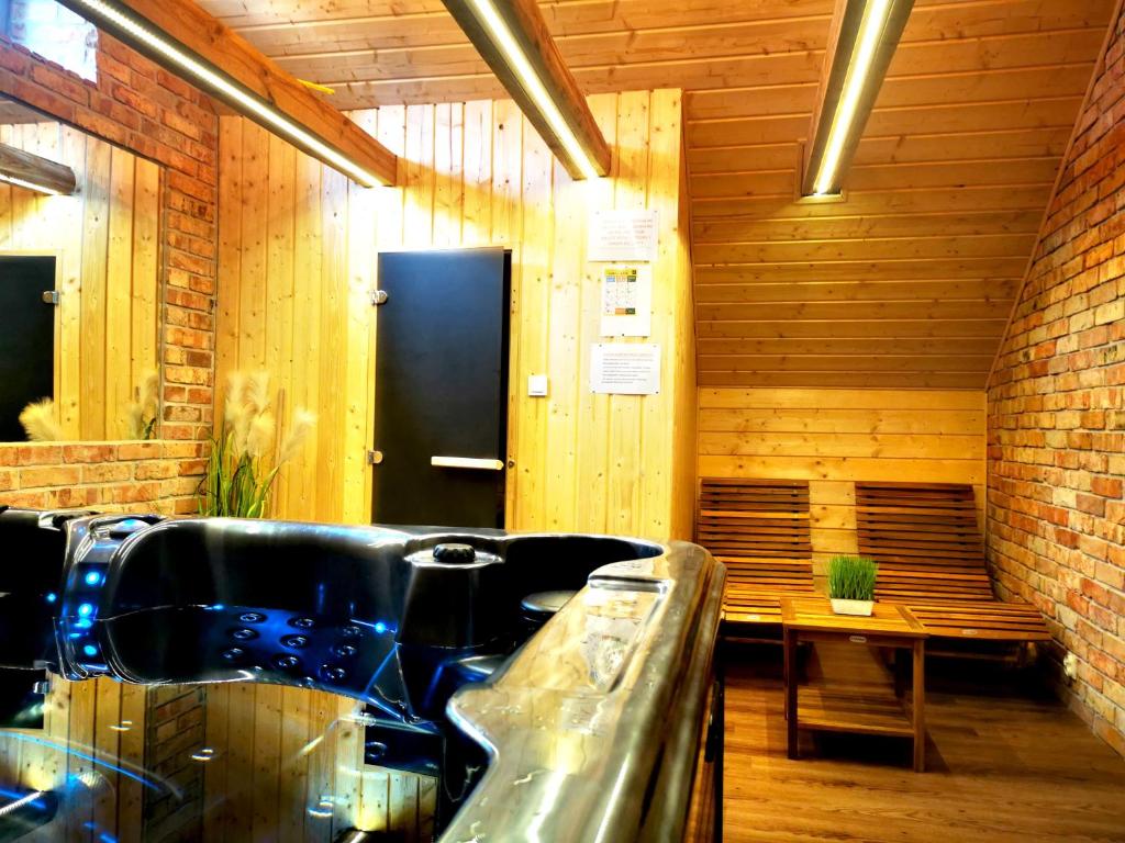 a bathroom with a tub and a bench in it at Apartament od Kaszuba in Żuromino
