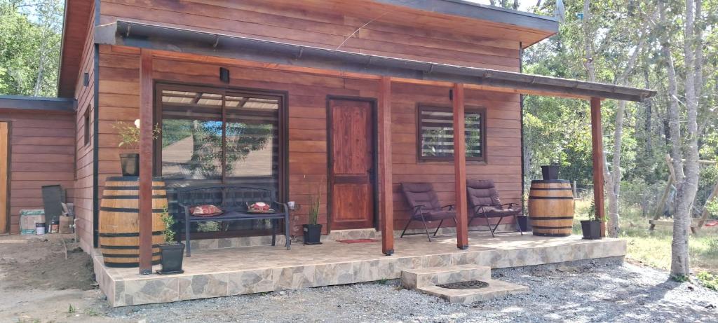 a tiny house with a porch and a fireplace at Pucón Rec-Lodge Camino al Volcan in Pucón