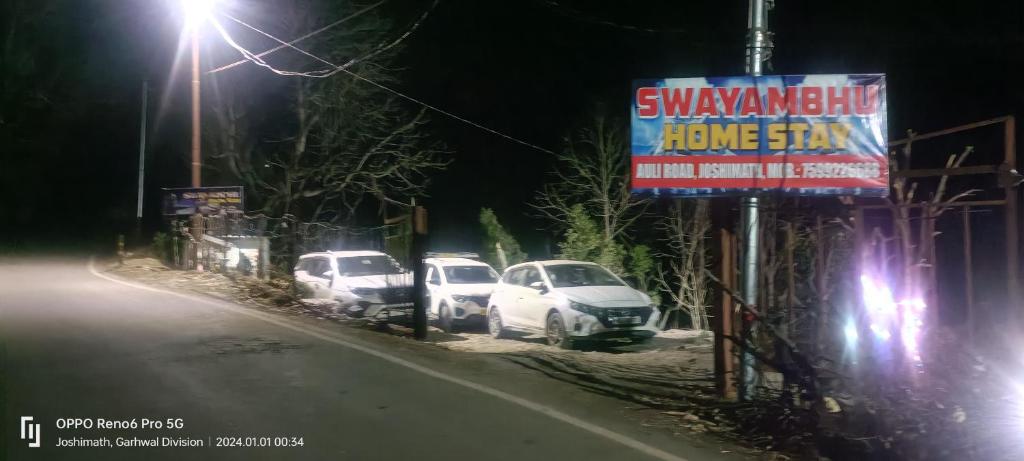 a group of cars parked on a street at night at swayambhu homestay in Joshīmath