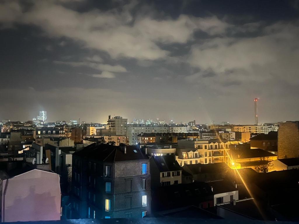 a view of a city at night at Parisian Skyline Oasis: Panoramic Elegance, Luxury at Your Doorstep in Saint-Ouen