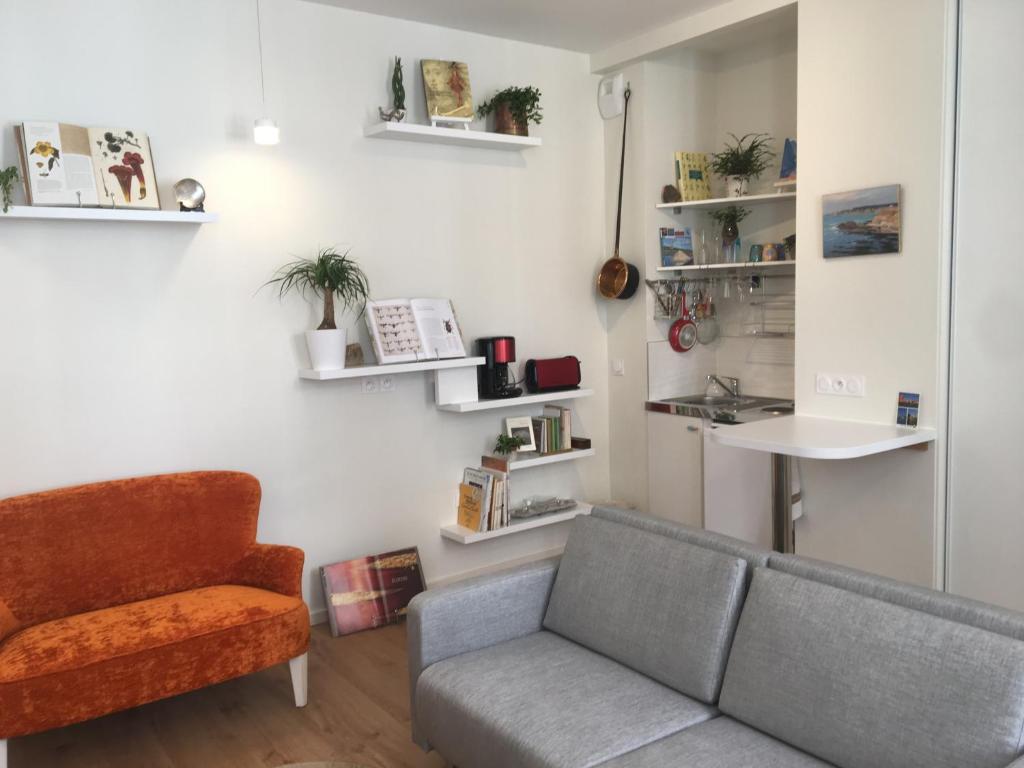 uma sala de estar com um sofá e uma cadeira em Appartement cœur vieille ville em La Rochelle