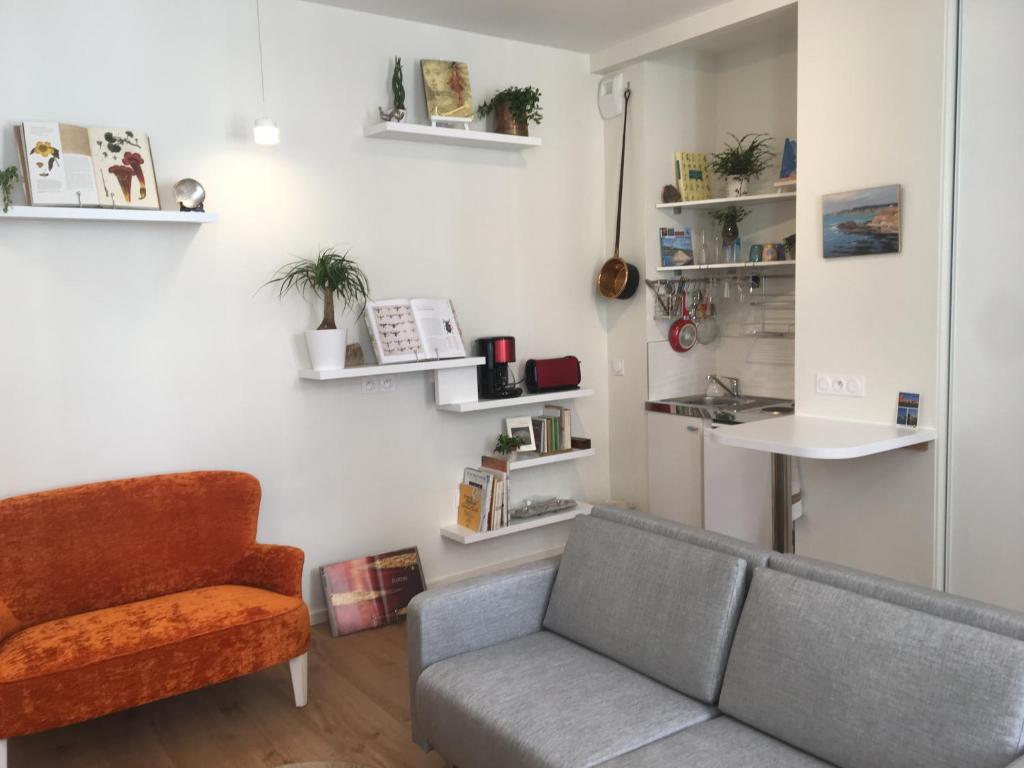 un salon avec un canapé et une chaise dans l'établissement Appartement cœur vieille ville, à La Rochelle