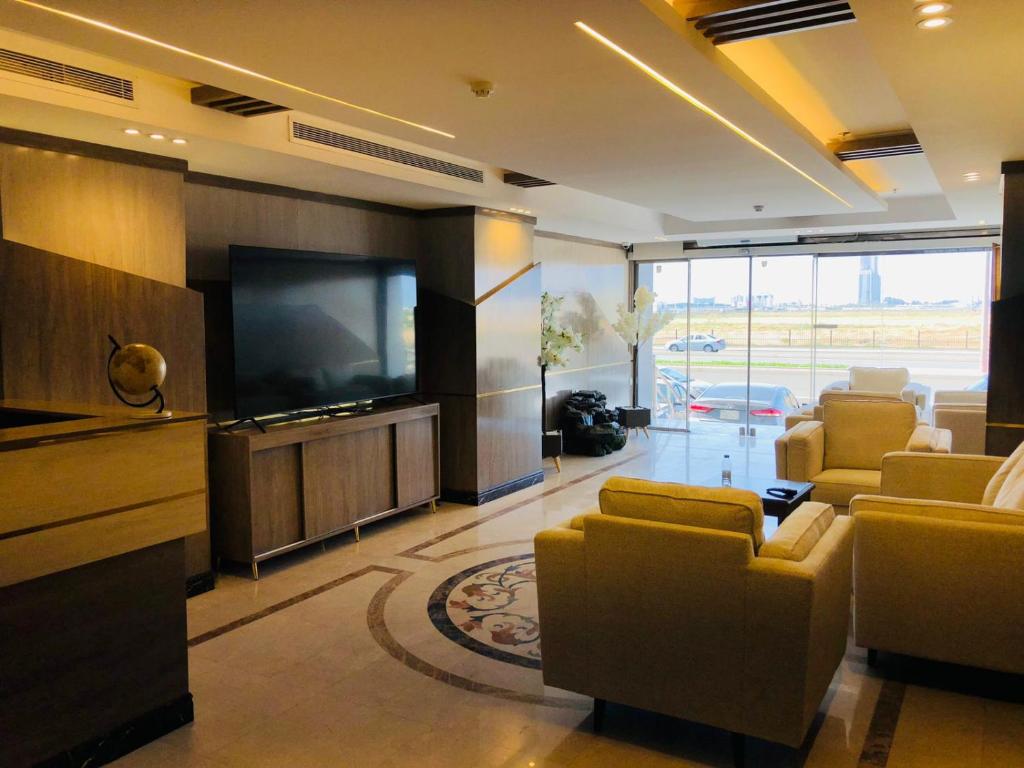 a living room with a flat screen tv and couches at شقق اطلالة أبحر للشقق المخدومة in Jeddah