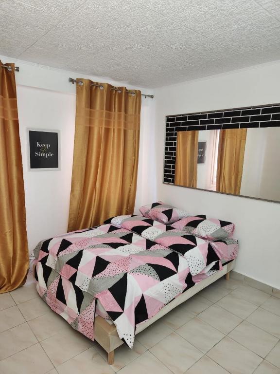 a bedroom with a bed with a black and white comforter at Au cœur de sarcelles in Sarcelles