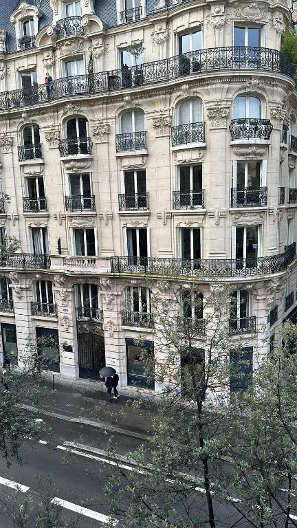 un grand bâtiment avec une personne debout devant lui dans l'établissement Cosy studio châtelets les halles, à Paris