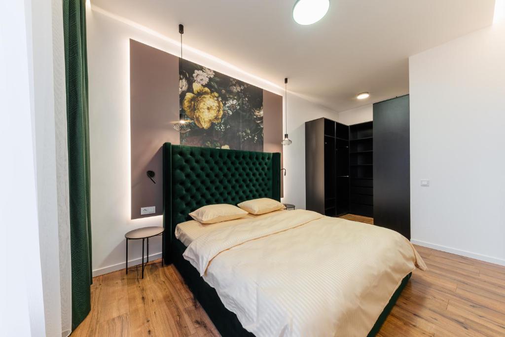 烏日霍羅德的住宿－Luxury Apartments Laborca，一间卧室配有一张大床和绿色床头板