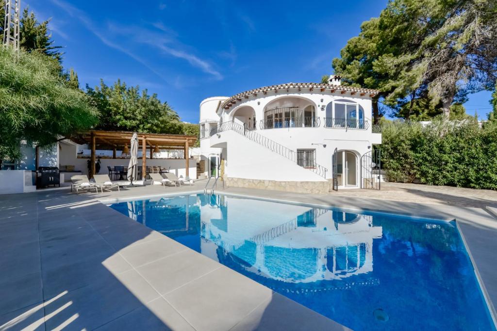 une villa avec une piscine et une maison dans l'établissement Villas Guzman - Casa Nova, à Moraira
