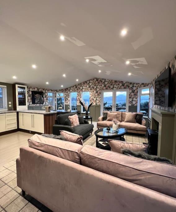 a large living room with couches and a kitchen at Luxury Lodge With Hot Tub In Royal Deeside in Strachan