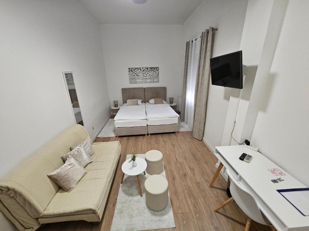 a living room with a couch and a bed at Drava Osijek in Osijek