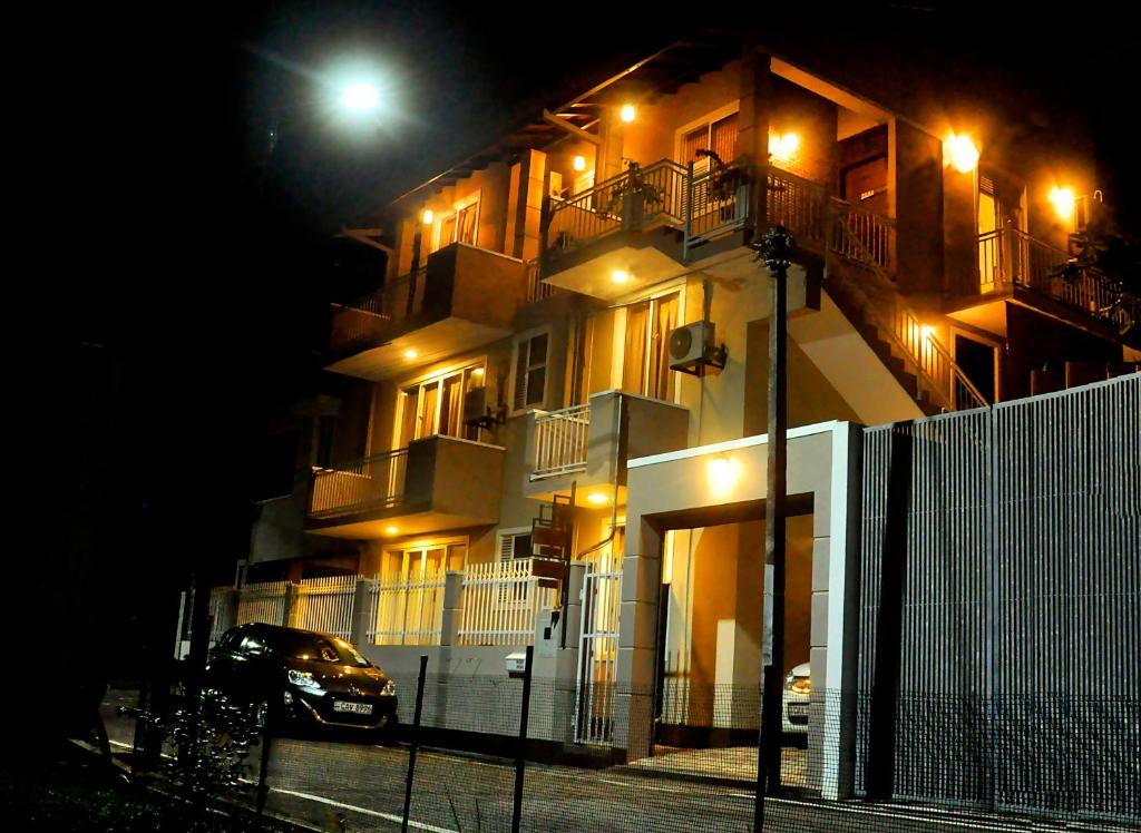 un bâtiment avec une voiture garée devant lui la nuit dans l'établissement Square One Heights - Kelaniya, à Kiribathgoda