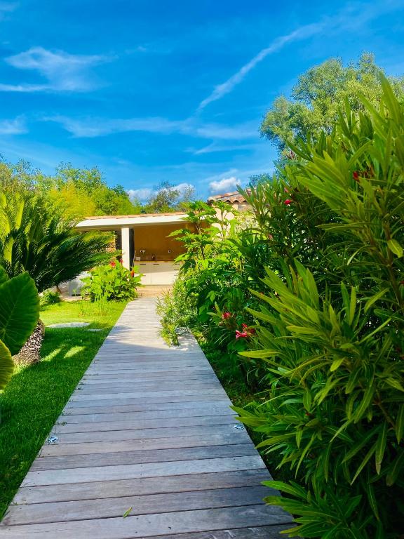 a wooden walkway leading to a house with plants at Le Cocoon Lodge du Gapeau &amp; Massage in Solliès-Pont