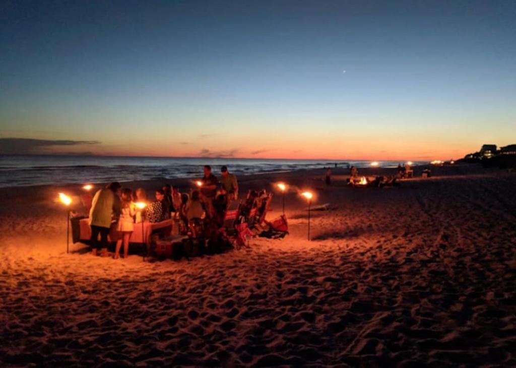 a group of people sitting at a table on the beach at night at New 30A Inlet Beach House - Sleeps 14 - 10 beds in Rosemary Beach