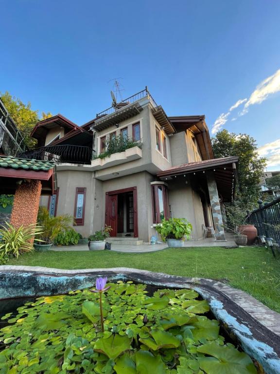 una casa con un estanque delante de ella en 中国蒲公英民宿Dandelion Guest house Villa with Mount View, en Kandy