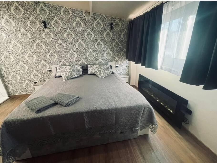 een slaapkamer met een bed en een muur met blauwe gordijnen bij Suites GREY in centro Randazzo in Randazzo