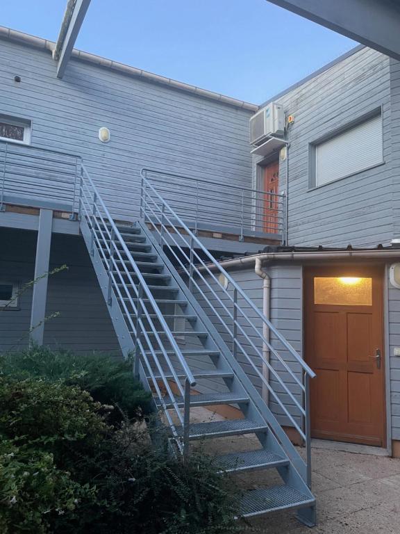 Un escalier mène à un bâtiment avec une porte. dans l'établissement Chambre meublé idéale pour déplacement d'affaires, à Le Petit-Quevilly