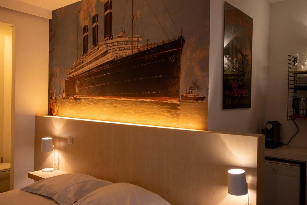 a bedroom with a picture of a cruise ship on the wall at Antwerp For Two B&B in Antwerp