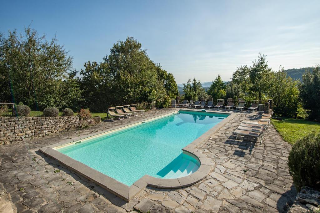 una piscina con sedie a sdraio intorno ad essa di Villa Case a Cantuccio a San Giustino