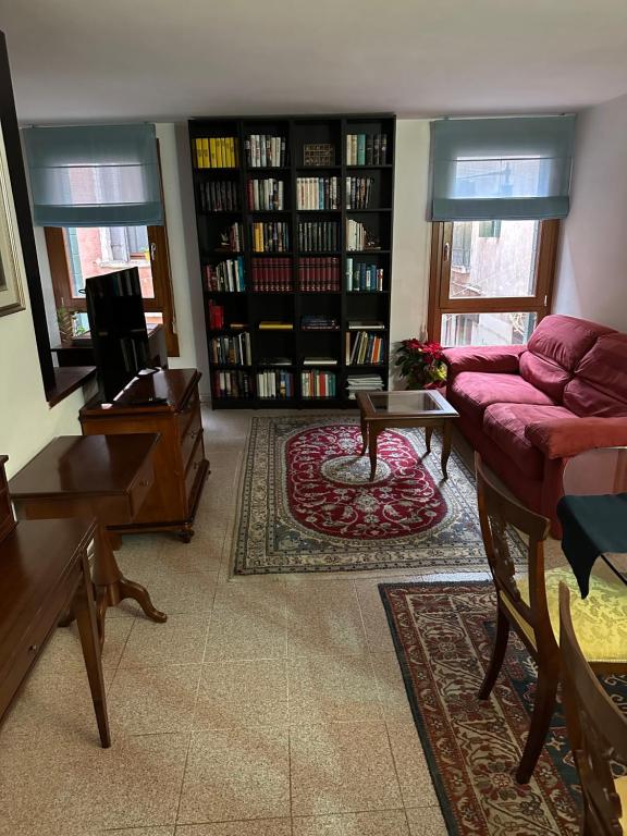 sala de estar con sofá púrpura y estanterías de libros en Appartamento Cà Lio, en Venecia